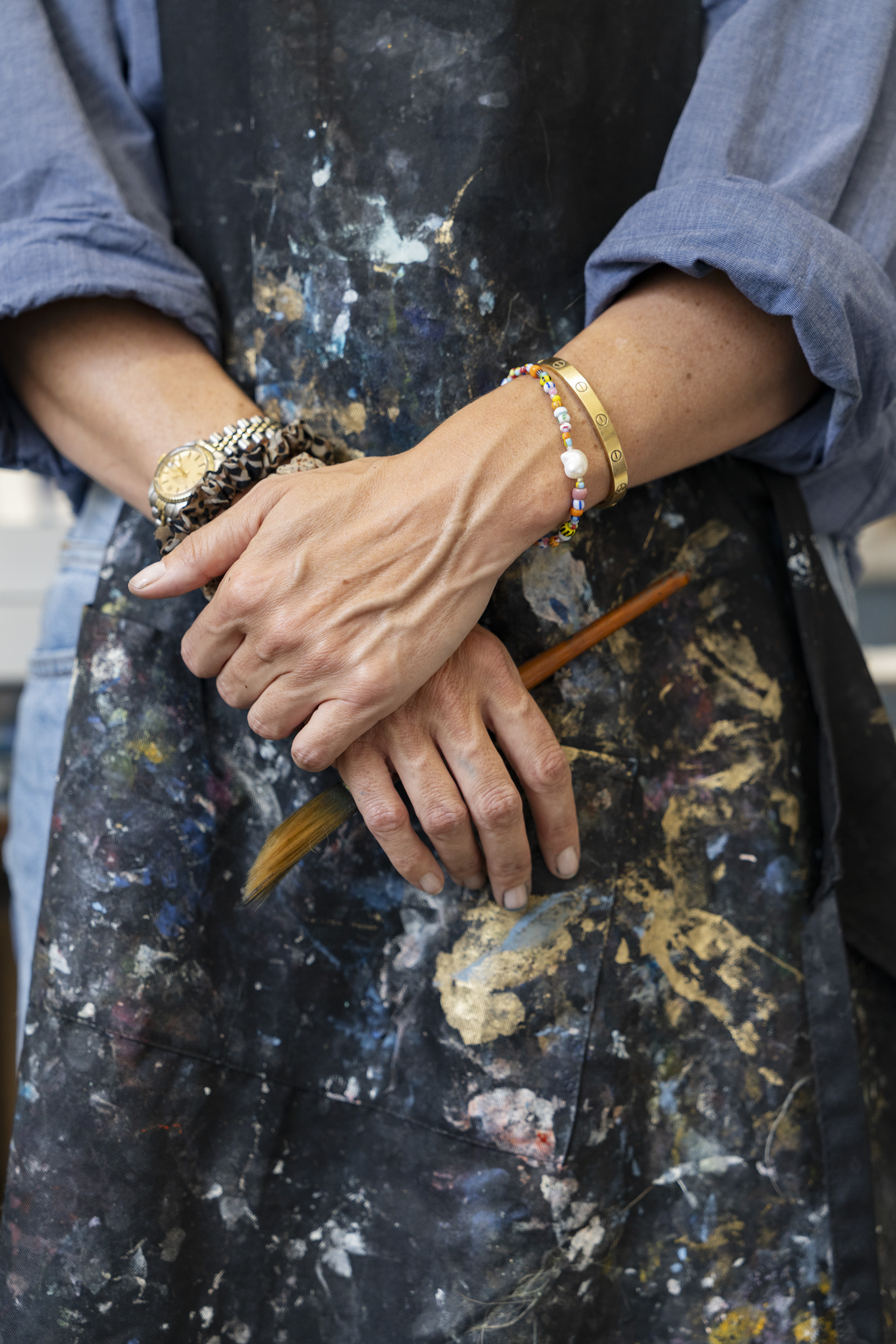 Photograph detail of artists hands. Caroline Tomlinson in her London studio, at work at her desk.