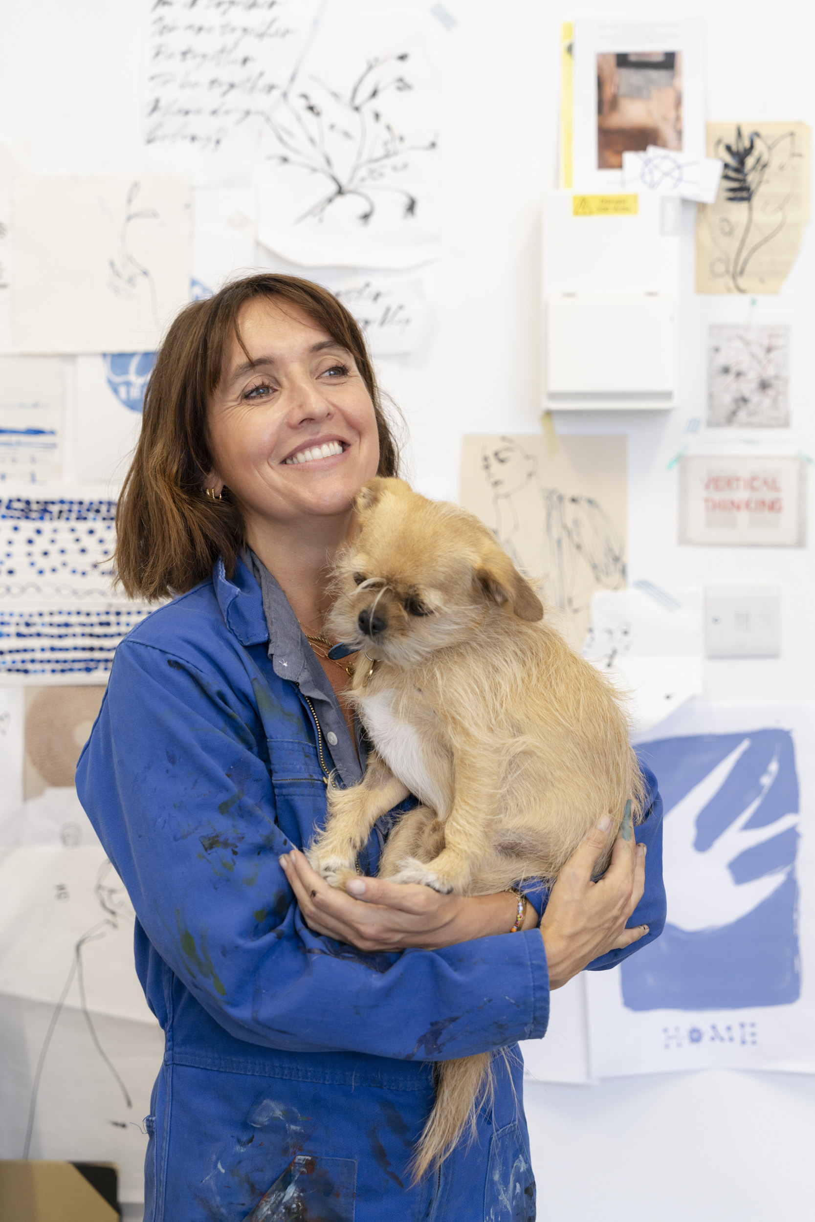 Photograph of illustrator Caroline Tomlinson in her London studio. With her dog Oscar.