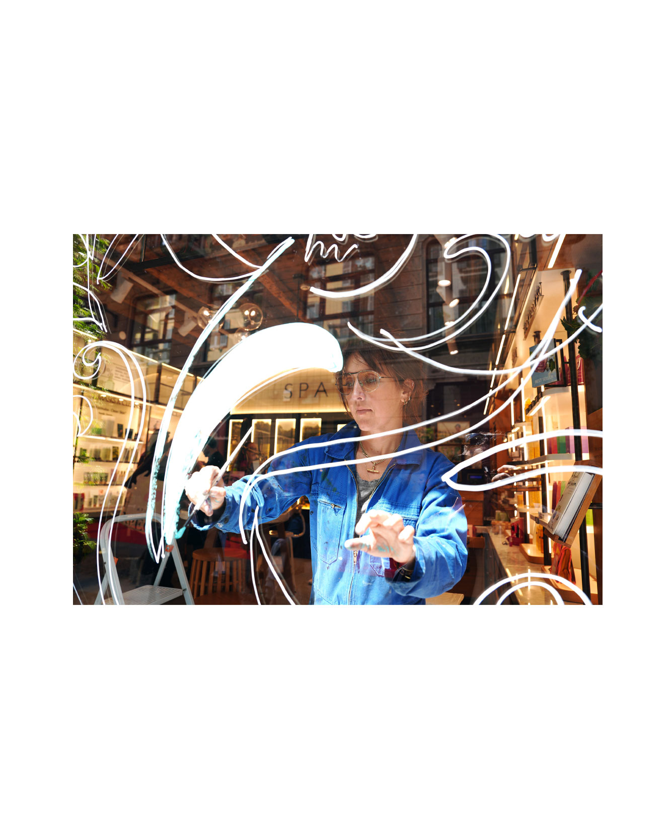 Artist live painting gestural botanical illustrations on large storefront windows during Milan Design Week for a luxury beauty brand, featuring fluid ink lines inspired by nature and fragrance.