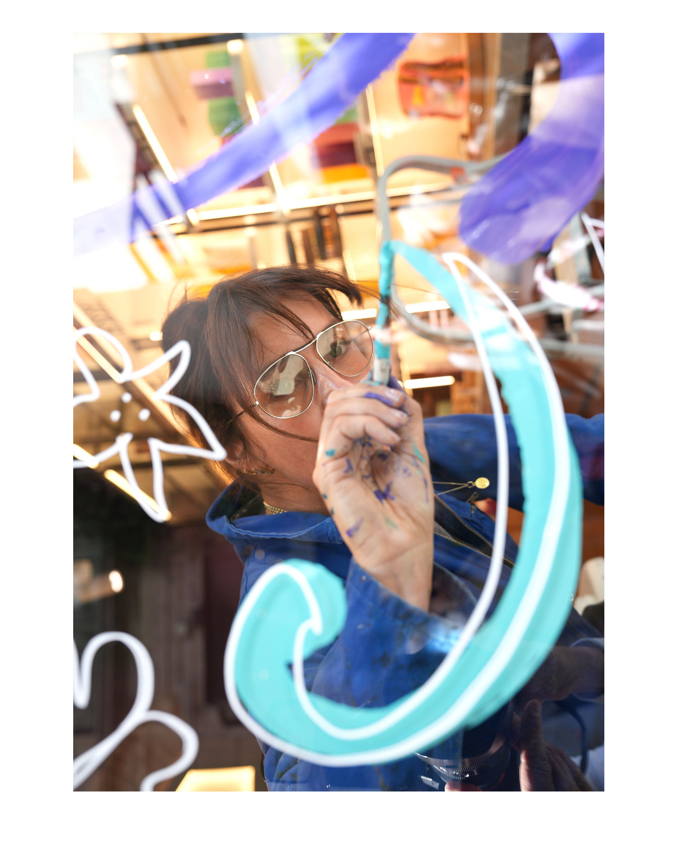 Artist live painting gestural botanical illustrations on large storefront windows during Milan Design Week for a luxury beauty brand, featuring fluid ink lines inspired by nature and fragrance.