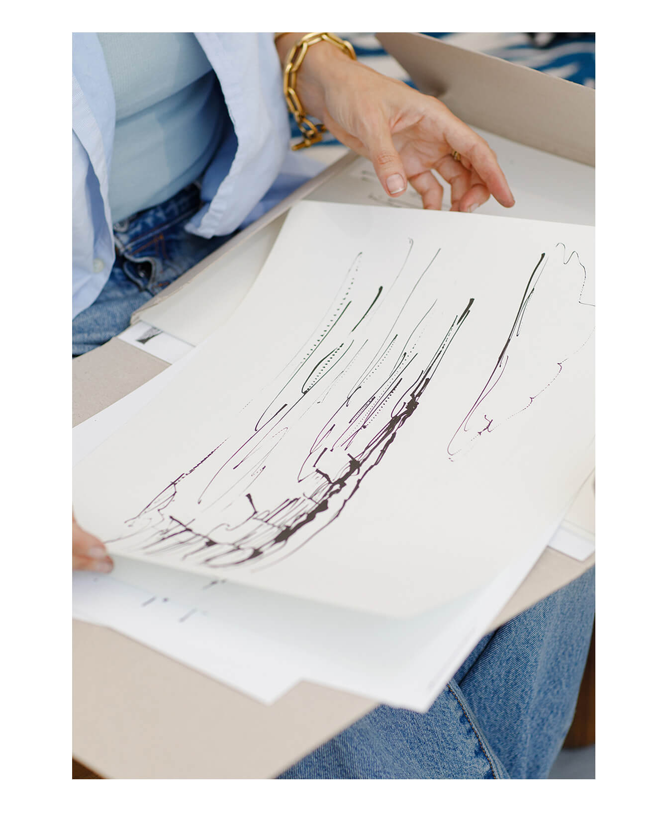 Caroline Tomlinson holding an abstract ink sketch from the Old Pultney harbour series